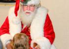 Santa Claus met this little one at the annual “Christmas with the Police” program on Dec. 9. The program by the Fayetteville Police Dept. is designed to bring Christmas presents and cheer to deserving children. Photo/Fayetteville Police.